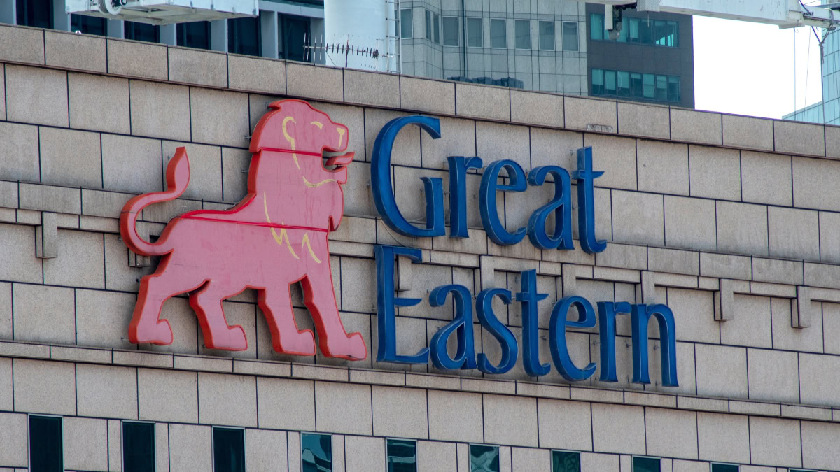 Red lion logo in pink with blue “Great Eastern” text on a beige brick wall of a building sign (corporate logo)