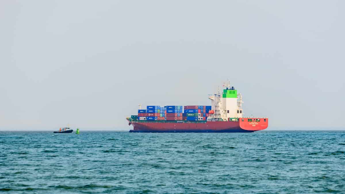 Large cargo ship navigating the Strait of Hormuz with containers onboard.