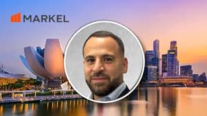 Portrait of a man in a suit inside a circular frame over a city skyline with the MARKEL logo in the top-left corner.