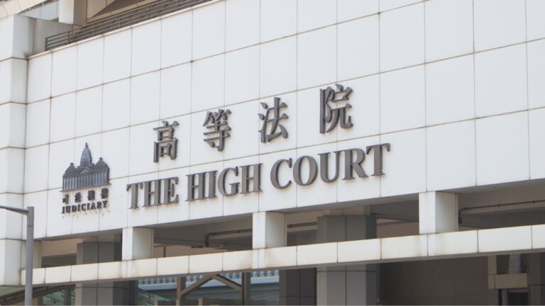 The High Court sign on a white building facade, with 'JUDICIARY' and Chinese characters visible near the entrance.