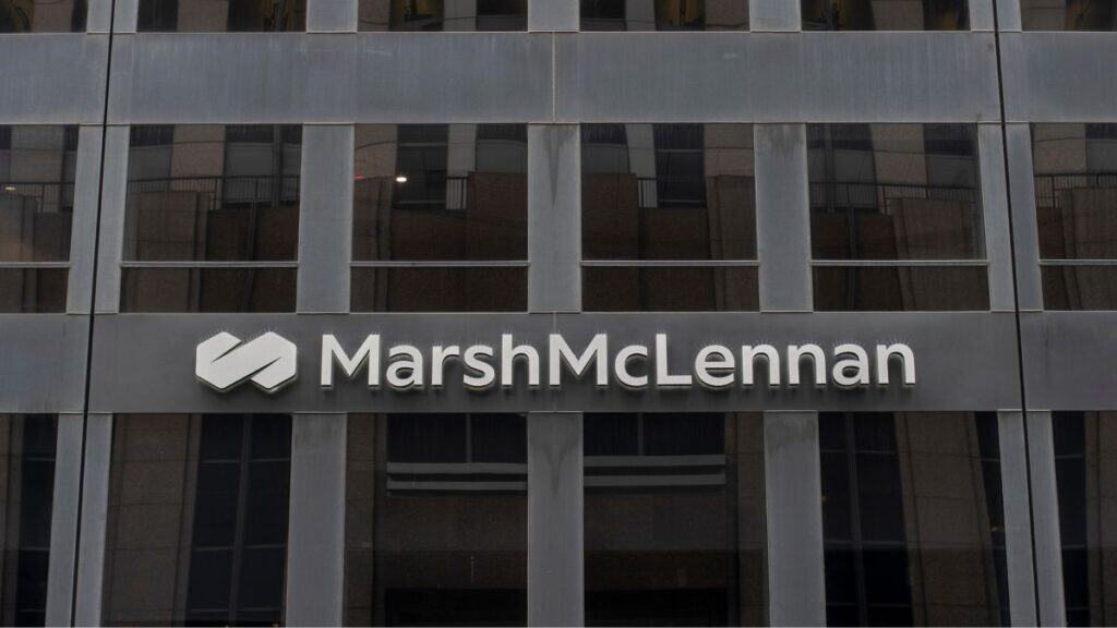 MarshMcLennan logo and sign on a modern glass office building façade