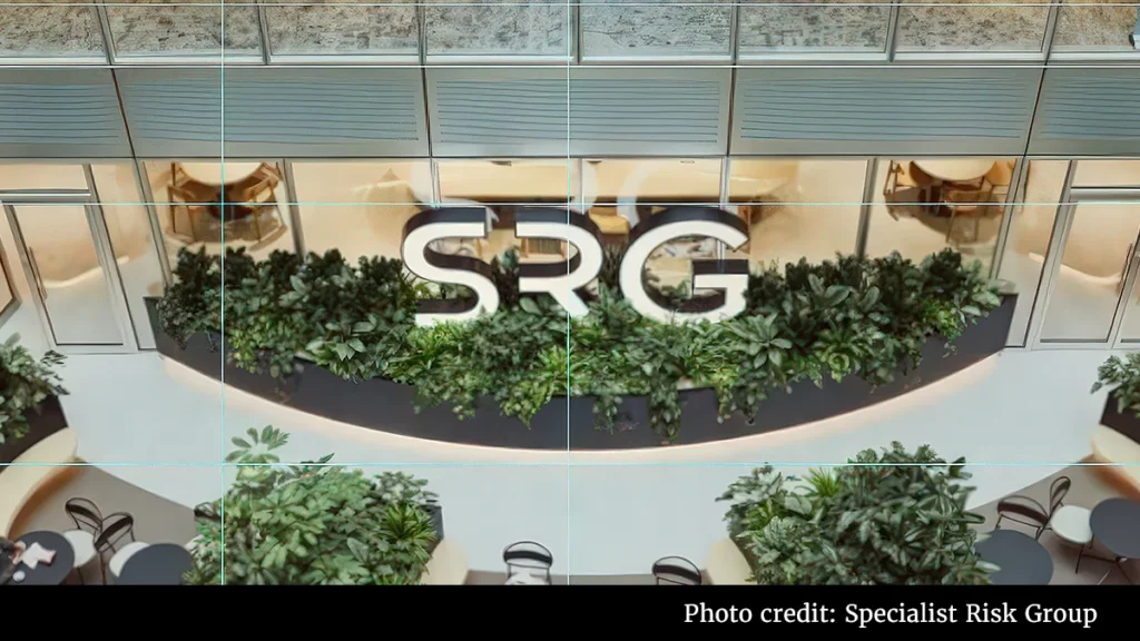 Indoor atrium with a lush green wall and a large SRG logo above it.