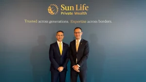 "Client globality": Sun Life rewires HNW business into single global platform Two men in dark suits with yellow ties stand in front of a Sun Life Private Wealth backdrop with slogan, posing for a photo at a formal event.
