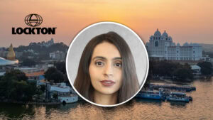 Portrait of a woman in a circle over a sunset cityscape with the Lockton logo in the background, suggesting a team spotlight feature.