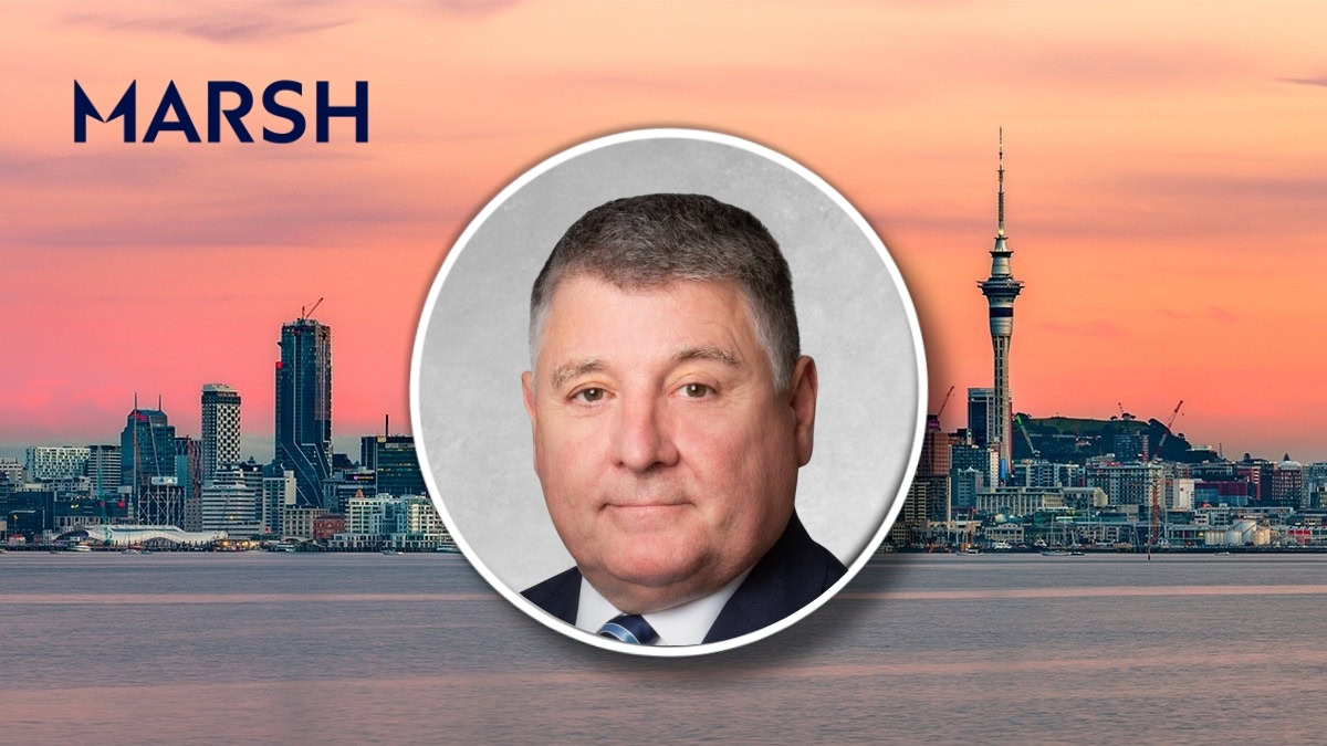 Corporate banner displaying the MARSH logo with a circular headshot of a suited man over a sunset city skyline backdrop.