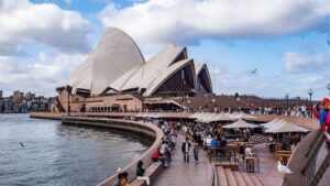 Australia's redrafted general insurance code risks ASIC rejection, code committee warns Sydney Opera House and Harbour Bridge in Australia with tourists and seagulls.