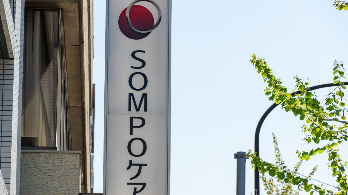 Vertical SOMPO sign with red circular logo mounted on a building.
