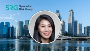 Smiling Asian woman’s headshot in a circular frame over a city skyline with the SRG Specialist Risk Group logo.