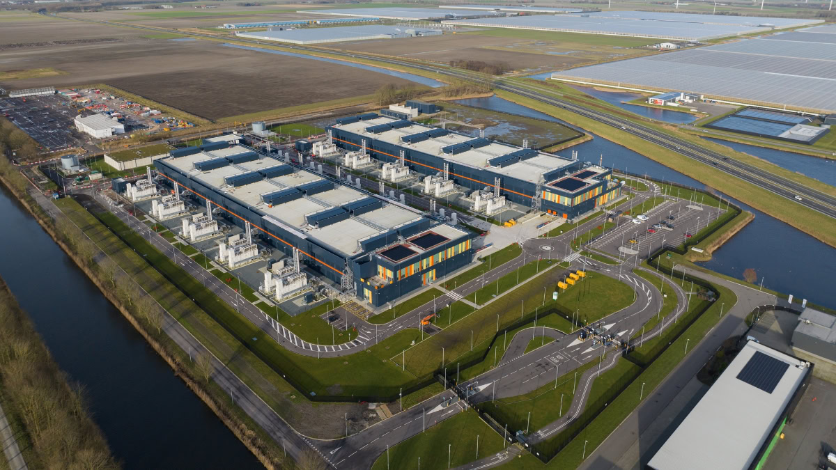 Aerial view of a modern data centre in the APAC region with solar panels and green spaces.