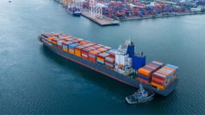 Large cargo ship with containers at an Asian port, highlighting shipping capacity.