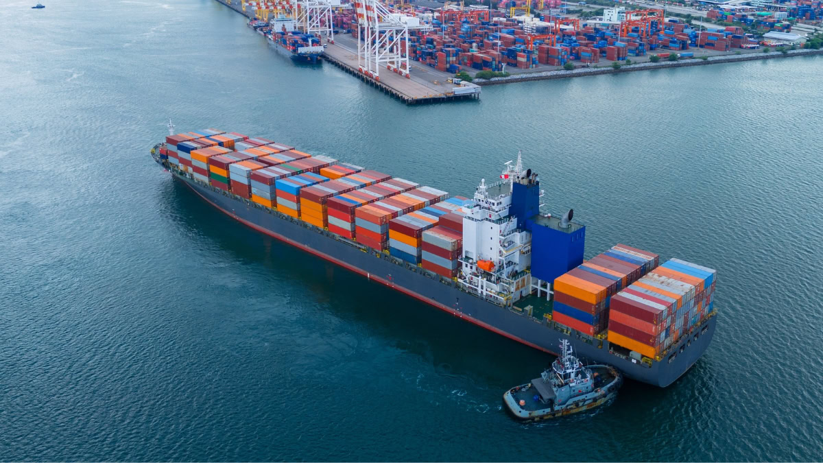 Large cargo ship with containers at an Asian port, highlighting shipping capacity.