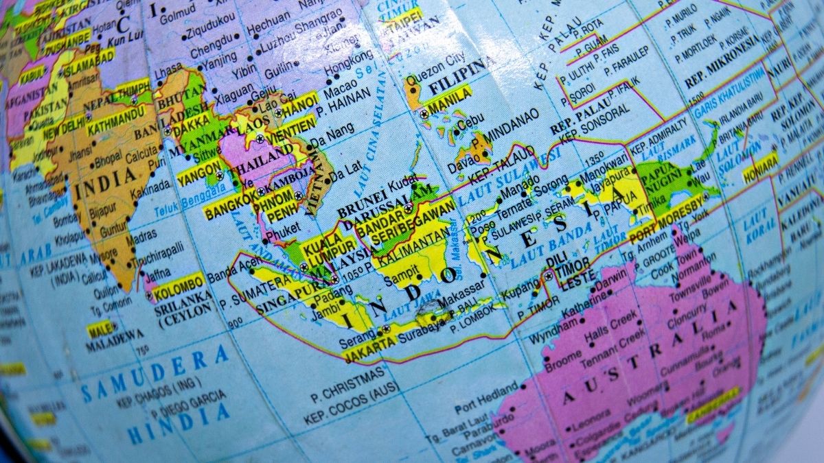 Close-up of a globe showing Southeast Asia and parts of India and Australia with country names highlighted in bright colors.