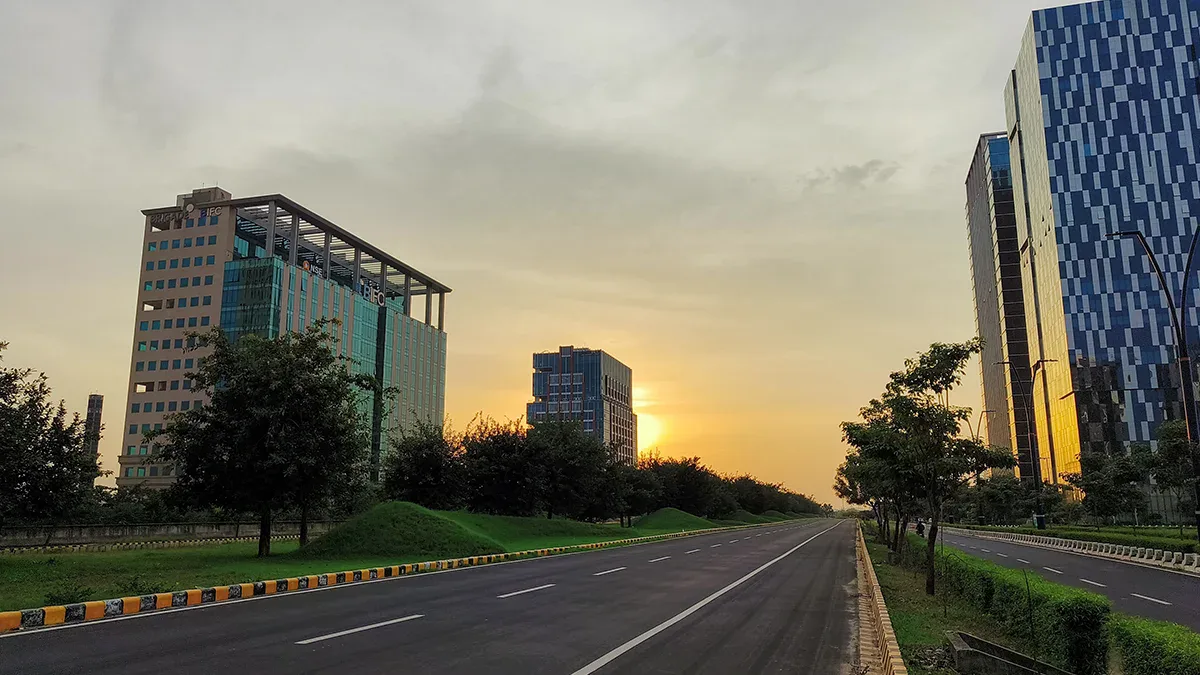 Modern cityscape with tall buildings near GIFT City, India, at sunset.