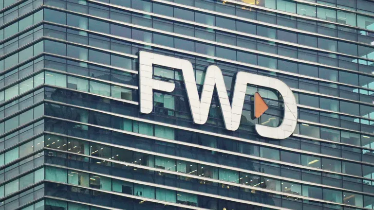Modern glass office building displaying the white FWD logo with an orange play icon on the facade.
