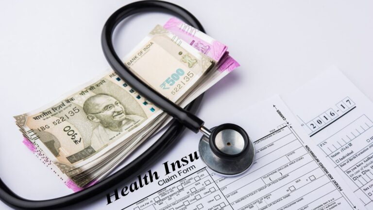 Indian 500 rupee notes with a stethoscope on health insurance claim form.