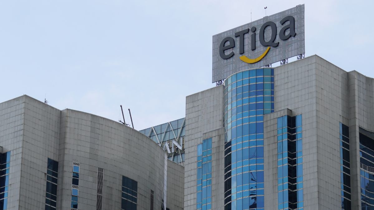 Modern office building with blue glass windows and a large EtIqa sign on the roof, featuring a yellow smile beneath the letters.