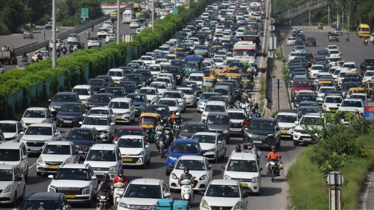 Traffic jam in India with cars and motorcycles on a busy road.