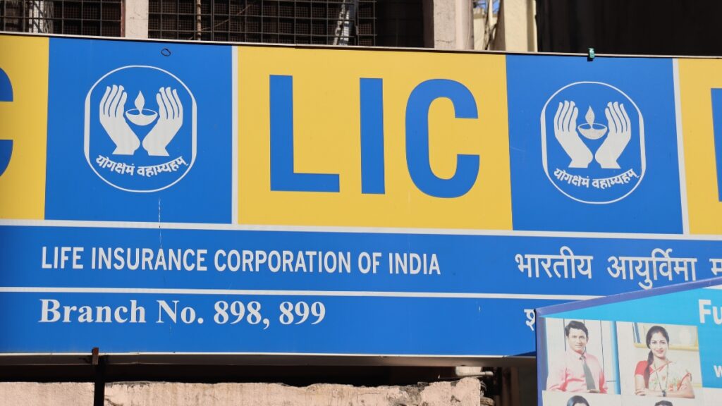 LIC signboard in India with branch numbers and logo, related to LIC's stake sale.