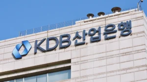 KDB 산업은행 (Korea Development Bank) sign on a beige stone building with a blue logo and Korean lettering, against a blue sky