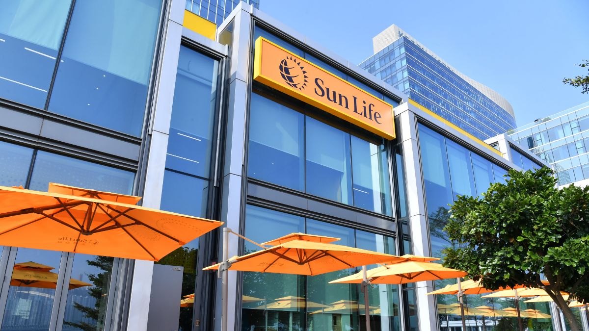 Sun Life Asia office building with glass facade and orange umbrellas outside.