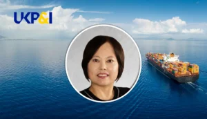 Jeong-Sook Kim, senior underwriting director, at UK P&I Club, with a cargo ship in the background.