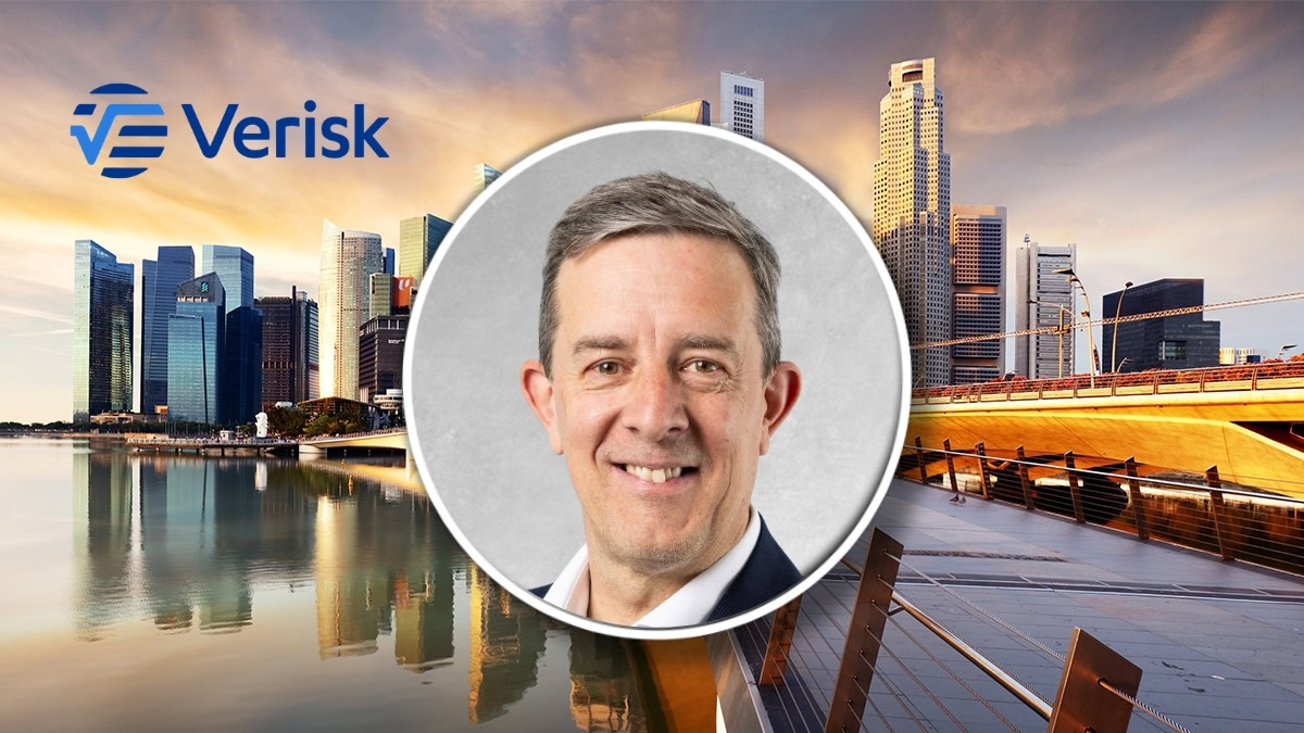 Business professional in front of Sydney skyline with Verisk logo.