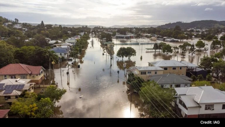 Flooded residential area in Australia after heavy rain, with submerged streets and houses.
