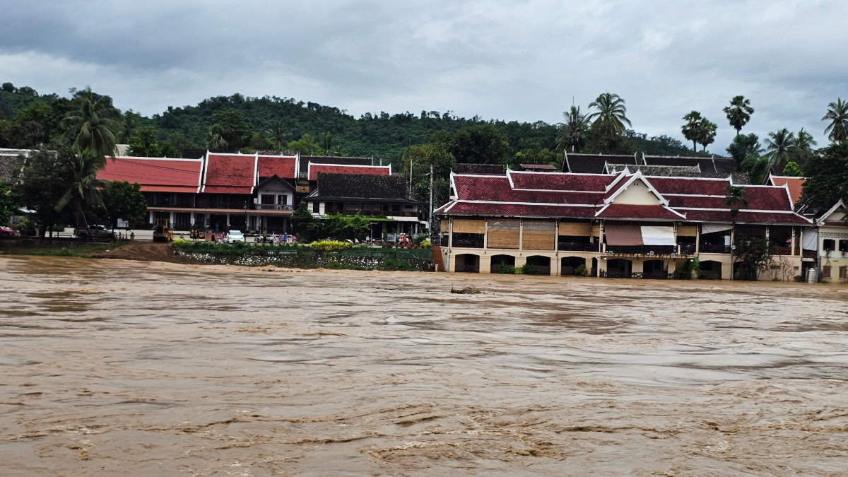 Flooded buildings in a tropical area, possibly in Thailand or Malaysia.