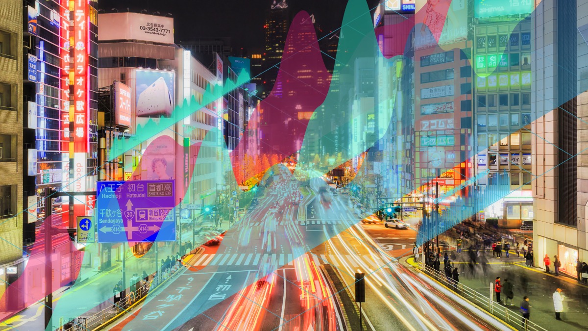 Bright city street at night with digital overlays and traffic in Tokyo, Japan.