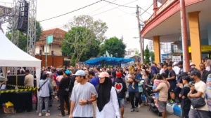 Indonesia health, credit lines remain pressure points as AM Best keeps non-life outlook stable Crowd gathers at an outdoor event in Indonesia, with a stage canopy, speakers and motorcycles lining the street.