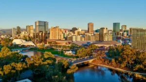 AUB Group to acquire One Underwriting Australia from Aon Adelaide skyline and convention centre beside the River Torrens, viewed across surrounding parkland.