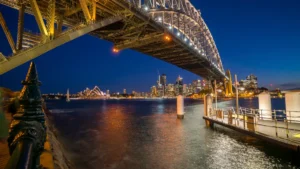 Challenger rejects TAL Dai-ichi Life’s takeover offer, leaves door open to talks Sydney Harbour Bridge spans the foreground above the harbour, with the Opera House and city skyline illuminated at night.