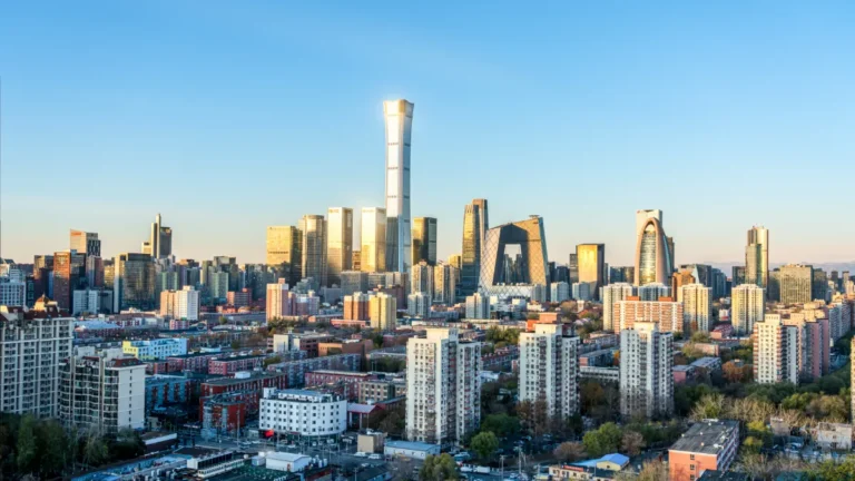 Beijing skyline with the CCTV headquarters and dense residential buildings in the foreground.