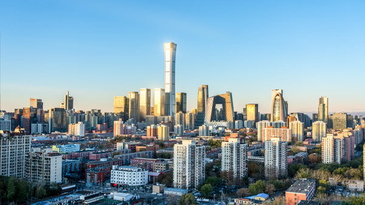 Beijing skyline with the CCTV headquarters and dense residential buildings in the foreground.