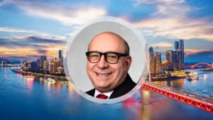 Generali puts China and India at the centre of its next APAC growth push Portrait of an unnamed APAC chief wearing glasses, set against a city skyline and illuminated bridge.