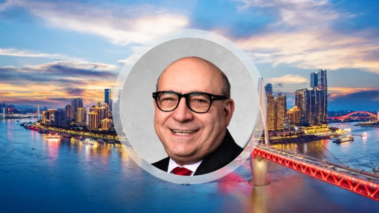 Portrait of an unnamed APAC chief wearing glasses, set against a city skyline and illuminated bridge.