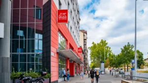 Generali, World Bank join forces to expand targeted insurance across emerging markets Generali building with red signs on a city street, with pedestrians walking outside.