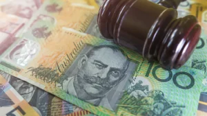 A wooden gavel rests on Australian dollar banknotes.