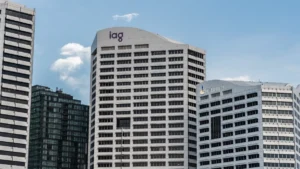 IAG offers to sell NRMA’s WA renewal rights in public benefit bid for RAC deal City office buildings displaying IAG and RAC logos beneath a blue sky.