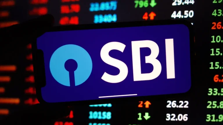 SBI logo displayed on a smartphone in front of a blurred stock market board.