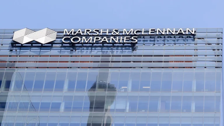 Marsh & McLennan Companies logo displayed on the glass façade of an office building.