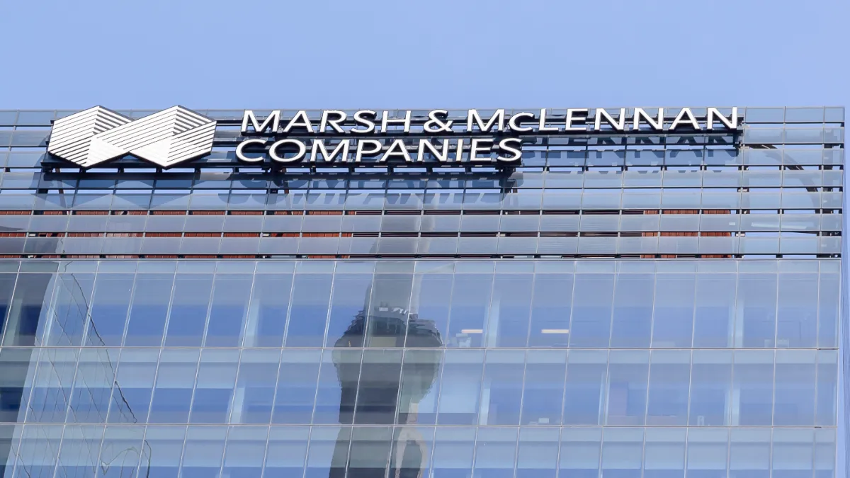 Marsh & McLennan Companies logo displayed on the glass façade of an office building.