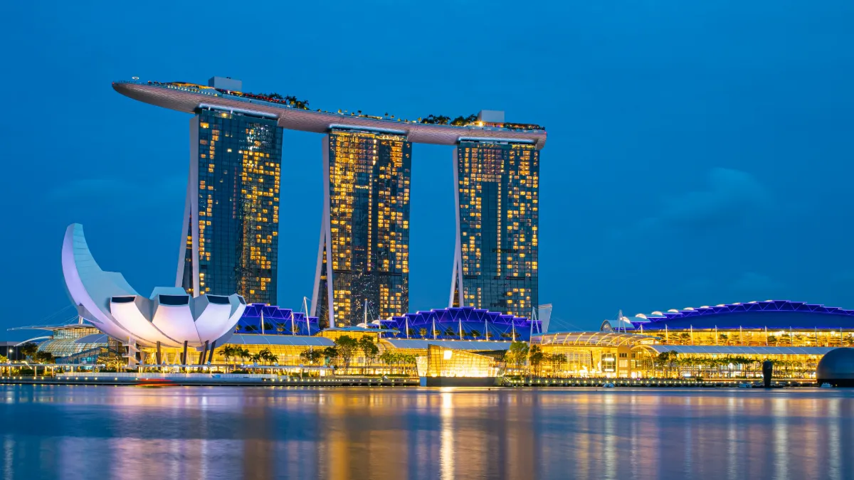 Marina Bay Sands and the ArtScience Museum illuminated beside Singapore’s waterfront at dusk.
