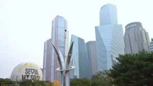 Seoul skyline with modern office towers and a “Seoul My Soul” sculpture in the foreground.