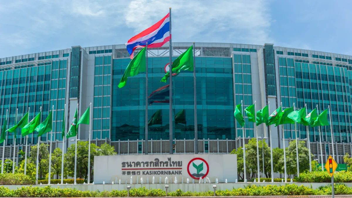 Kasikornbank headquarters with Thai and green flags outside.