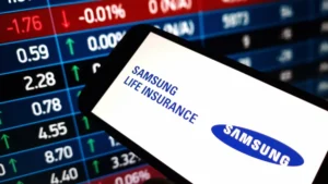 Samsung Life to raise US$1.5bn through offshore hybrid bond to strengthen solvency Samsung Life Insurance logo displayed on a smartphone over a stock market board.