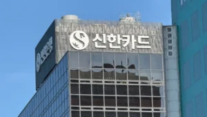 Shinhan Financial to acquire 77% of Lotte Non-Life for US$516m Shinhan Card logo on the facade of a modern office building against a blue sky.