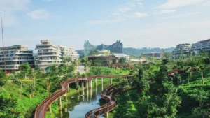 Sompo launches dedicated syariah general insurer in Indonesia Modern buildings surround a lush park with winding wooden walkways over a narrow waterway.