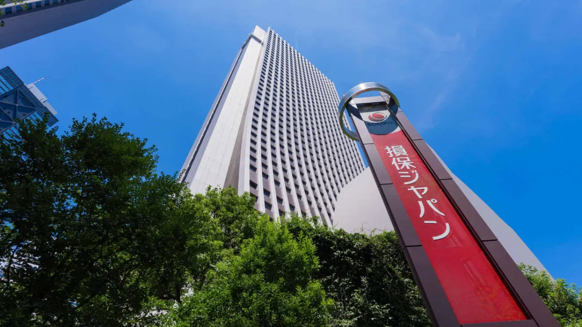 Sompo Japan sign outside a tall office building beneath a bright blue sky.
